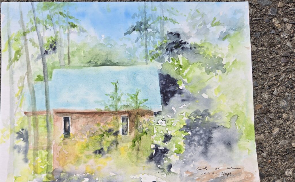 A watercolour painting of a blue-roofed cottage tucked into the woods.