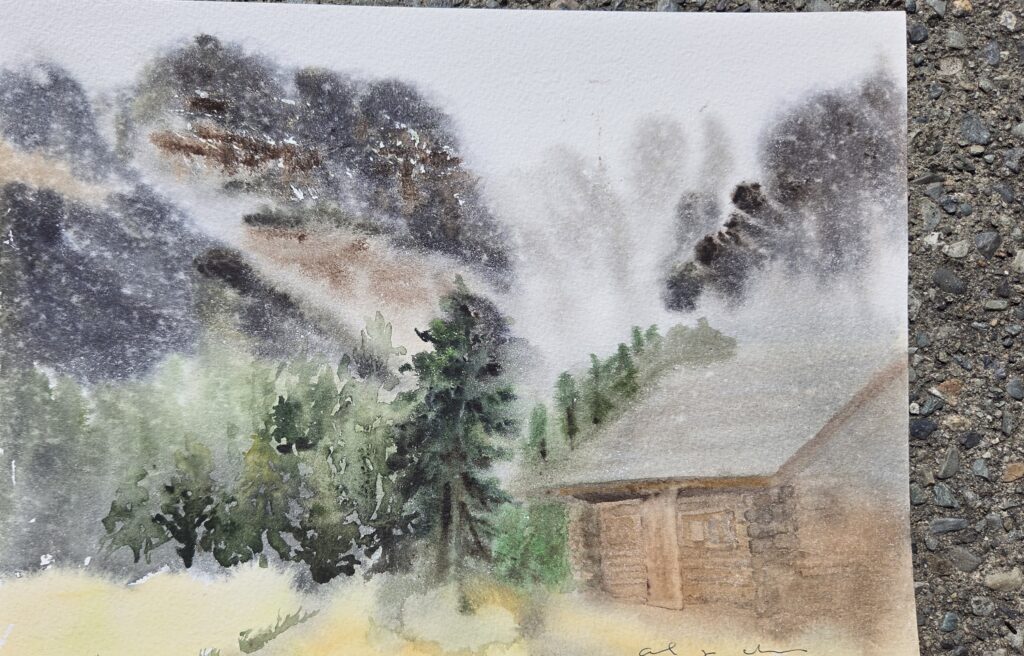 A watercolour painting of a log cabin nestled in misty mountain foothills.